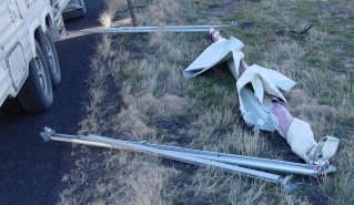 Photo of a ripped-off awning laying beside the fifth-wheel trailer.